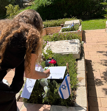 חניכת בית קקל למצוינות בקריית מלאכי מניחה מכתב על קבר חלל. צילום: רביד טיירו