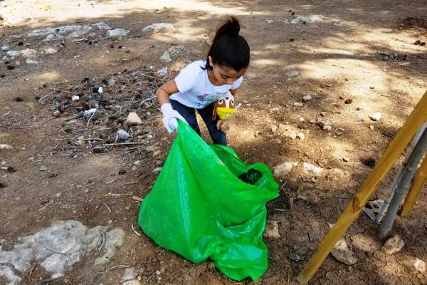 גם בת המשפחה הצעירה נרתמת לנקות את היער. צילום: פולה כהן, קק"ל