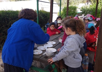 ילדות סביב שולחן, באמצע צלחות עם זרעים