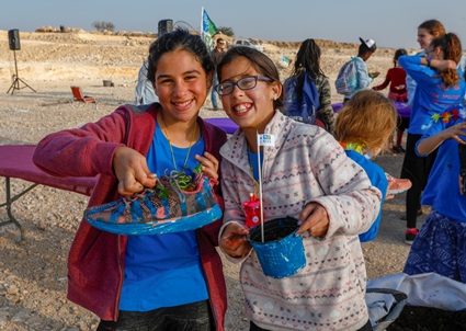 שתי ילדות עם נעל שמשמשת עציץ