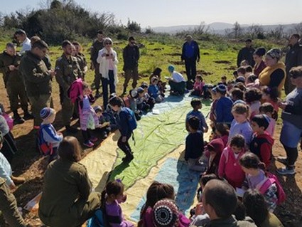 ילדים ומבוגרים סביב משחק משימות של קק"