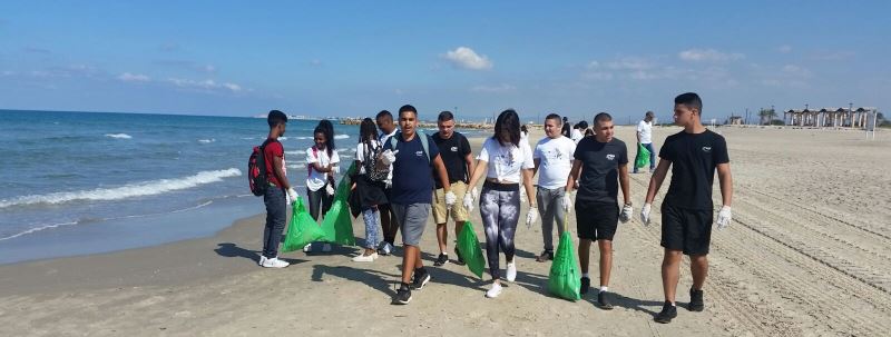 קבוצת בני נוער מנקה את חוף הים