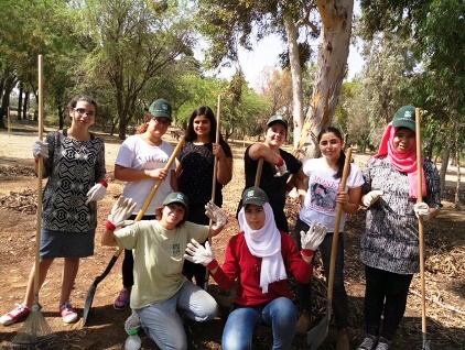 קבוצת ילדים ביער עם כלי עבודה