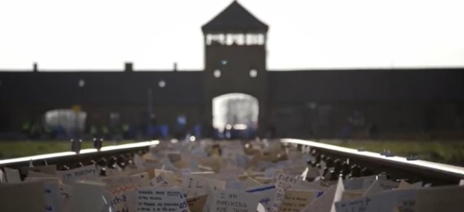 Never Means Never: השלטים הווירטואלים על מסילת הרכבת בבירקנאו. תצלום מתוך סרטון הפרומו למצעד החיים הווירטואלי