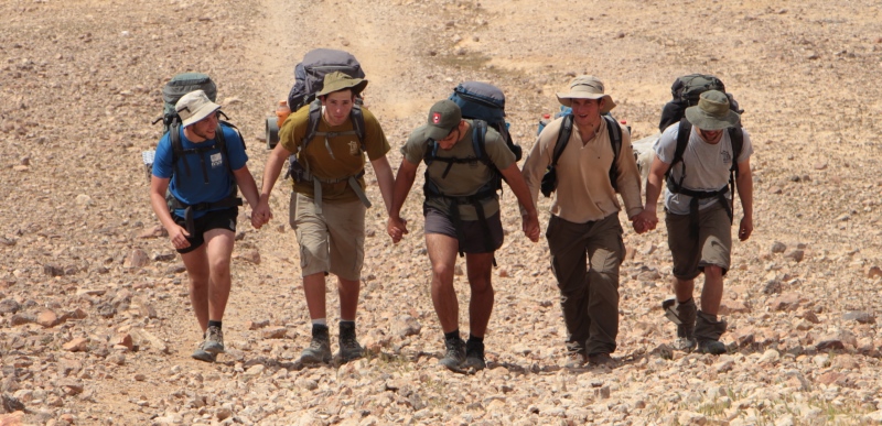 חמישה קדצניקים במדבר צועדים עם תרמילים על הגב