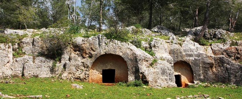 הכניסות למערות הקבורה בחורבת חרמש, החצובות בצורת קשת. צילום: יעקב שקולניק