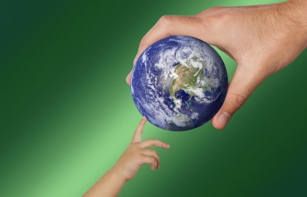 צילום אילוסטרציה: יד של ילד נוגעת בכדור הארץ