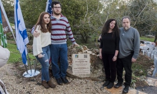 ההורים רנה ודויד (מימין) והאחים דנה ומייקל (משמאל) ליד שלט ההצחה לאלי גולדנברג ז"ל.  צילום: דניס צין