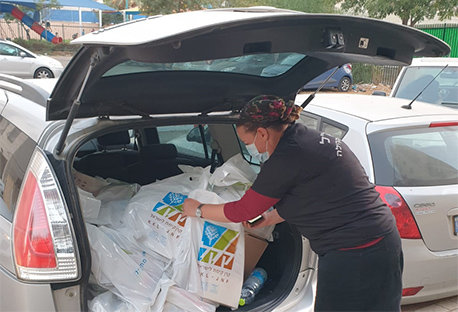 מתנדבת מכינה חבילות שי מקק"ל לחלוקה במסגרת פרויקט קק"ל למען הקהילה. 
