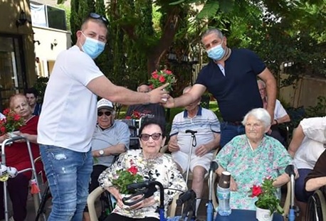 יו"ר הארגון ישראל גולדשטיין (משמאל) משמח את הקשישים בפרחים. צילום: ארגון העובדים הארצי, קק"ל