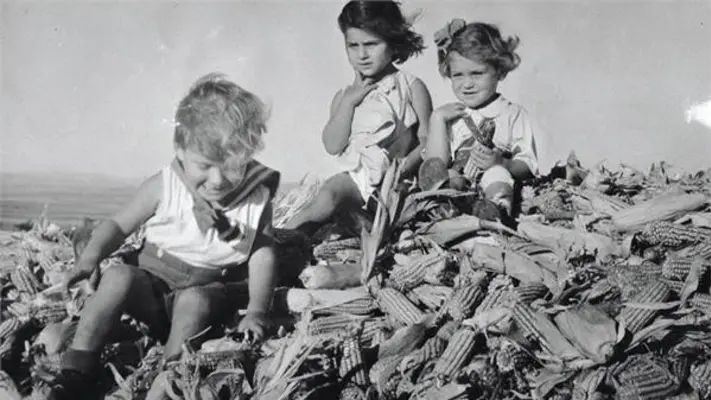 ילדים בקיבוץ יושבים על קלחי תירס | צילום: אברהם מלבסקי, ארכיון קק"ל | 1935
