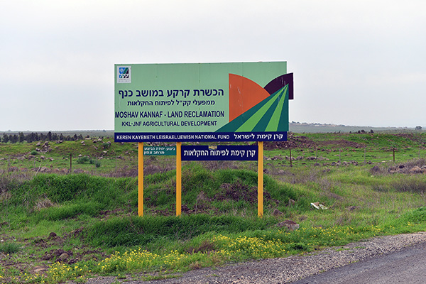 שלט הפרויקט על רקע הקרקע שהוכשרה לחקלאות.  צילום: מיכאל חורי, ארכיון הצילומים של קק"ל