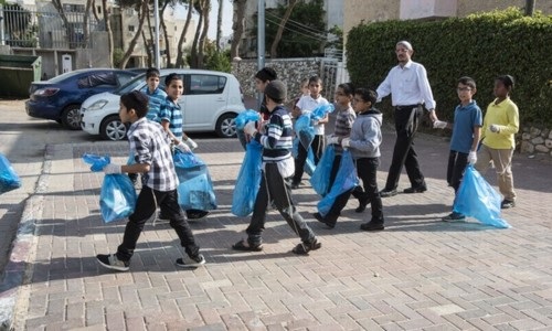 מורה ותלמידיו  מנקים את העיר קרית מלאכי.  צילום: דניס צין