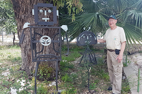 סשה ליד פסל שיצר מחומרים ממוחזרים במסגריית קקל בכברי.  צילום: מירה זר